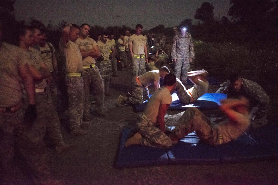 Army Reserve and National Guard combat engineer competitors perform situps during the Sapper Stakes 2015 Army Physical Fitness Test on Fort Chaffee, Ark., Aug. 31, 2015. U.S. Army photo by Master Sgt. Michel Sauret 