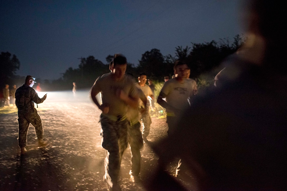 Army Reserve and National Guard combat engineer competitors take off for a 2-mile run during the Sapper Stakes 2015 Army Physical Fitness Test in the darkness of morning on Fort Chaffee, Ark., Aug. 31, 2015. U.S. Army photo by Master Sgt. Michel Sauret