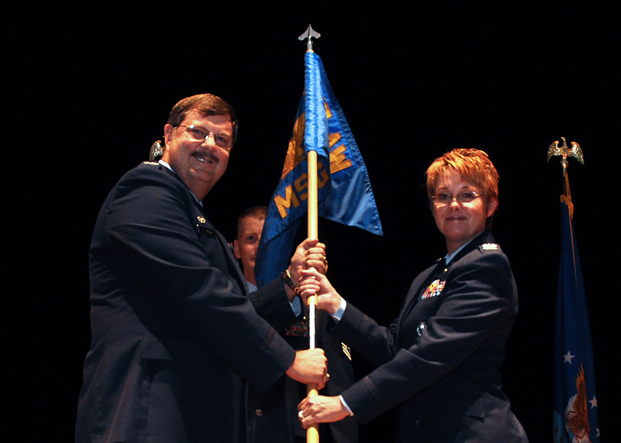 Col. Gregory Gilmour, 315th Airlift Wing commander, passes the 315th Mission Support Group guidon to Col. Cherie Roff, new 315th MSG commander, during an assumption of command ceremony at Joint Base Charleston, S.C. Sept. 13, 2015. (U.S. Air Force Photo by Senior Airman Tom Brading)