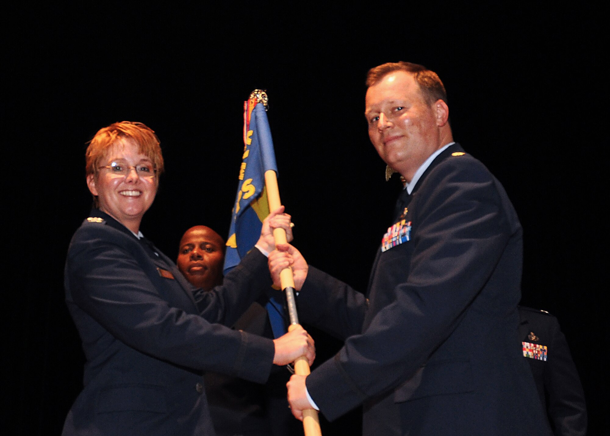 Col. Cherie Roff, 315th Mission Support commander, passes the guidon to Maj. Thomas Klauer, new 81st Aerial Port Squadron commander, during an change of command ceremony at Joint Base Charleston, S.C. Sept. 13, 2015. (U.S. Air Force Photo by Senior Airman Tom Brading)