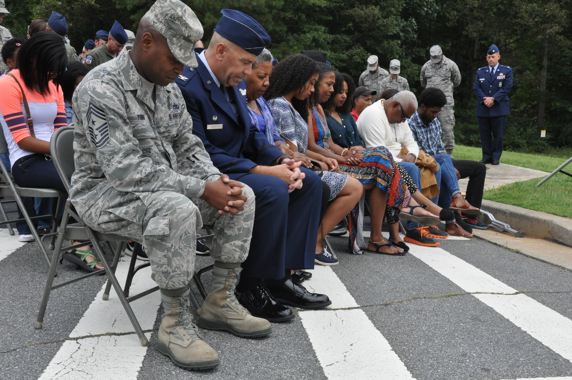 Chief Master Sgt. Lyndon Tubbs, 94th Airlift Wing command chief, Col. Brett Merritt, 94th AW commander, and family members of Lt. Col. Aundra Billups’ family pray at the Billups Avenue road dedication on Dobbins Air Reserve Base, Ga. Sep. 12, 2015. Billups, a former Dobbins pilot, passed away on Sep. 11, 2013 after a fight with cancer, and was honored with a road dedication in his name. (U.S. Air Force photo/ Senior Airman Miles Wilson)