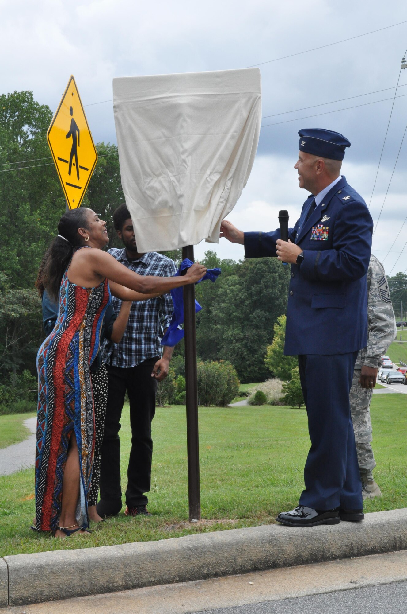 Members of Lt. Col. Aundra Billups’ family unveil Billups Avenue with Col. Brett Merritt, 94th Airlift Wing commander, at Dobbins Air Reserve Base, Ga. Sep. 12, 2015. Billups, a former Dobbins pilot, passed away Sep. 11, 2013, was honored by receiving a road dedication in his name. (U.S. Air Force photo/ Senior Airman Miles Wilson)