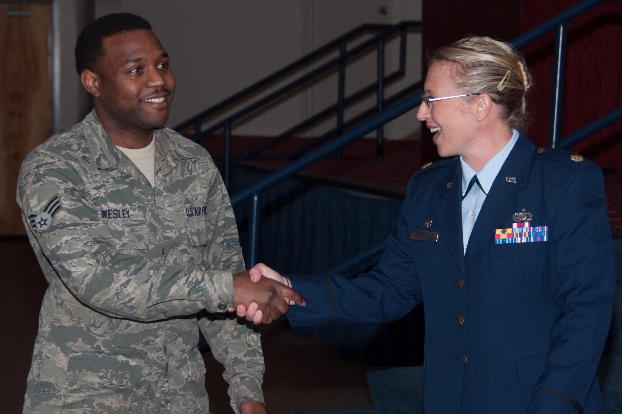 U.S. Air Force Senior Airman Xavier Wesley congratulates Maj. Beth Hart, commander of the 307th Force Support Squadron and her family on assuming command of the 307th Force Support Squadron on Barksdale Air Force Base, Louisiana, September 12, 2015. Hart is the former 307 Bomb Wing Executive Officer. (U.S. Air Force photo by Master Sgt. Laura Siebert/Released)