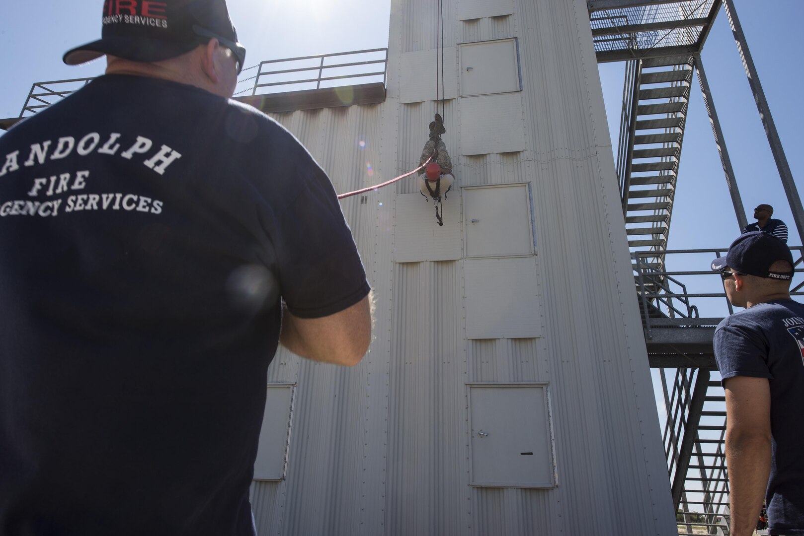 Michael Coscrelli and Senior Airman Christian Torres, Joint Base San Antonio-Randolph firefighters, perform a repelling demonstration during the JBSA Battle of the badges Sept. 12, 2015, at JBSA-Randolph. Battle of the Badges takes place each year to build camaraderie, espirit de corps and cohesion among JBSA first responders through various competitive challenges taken from their daily missions.