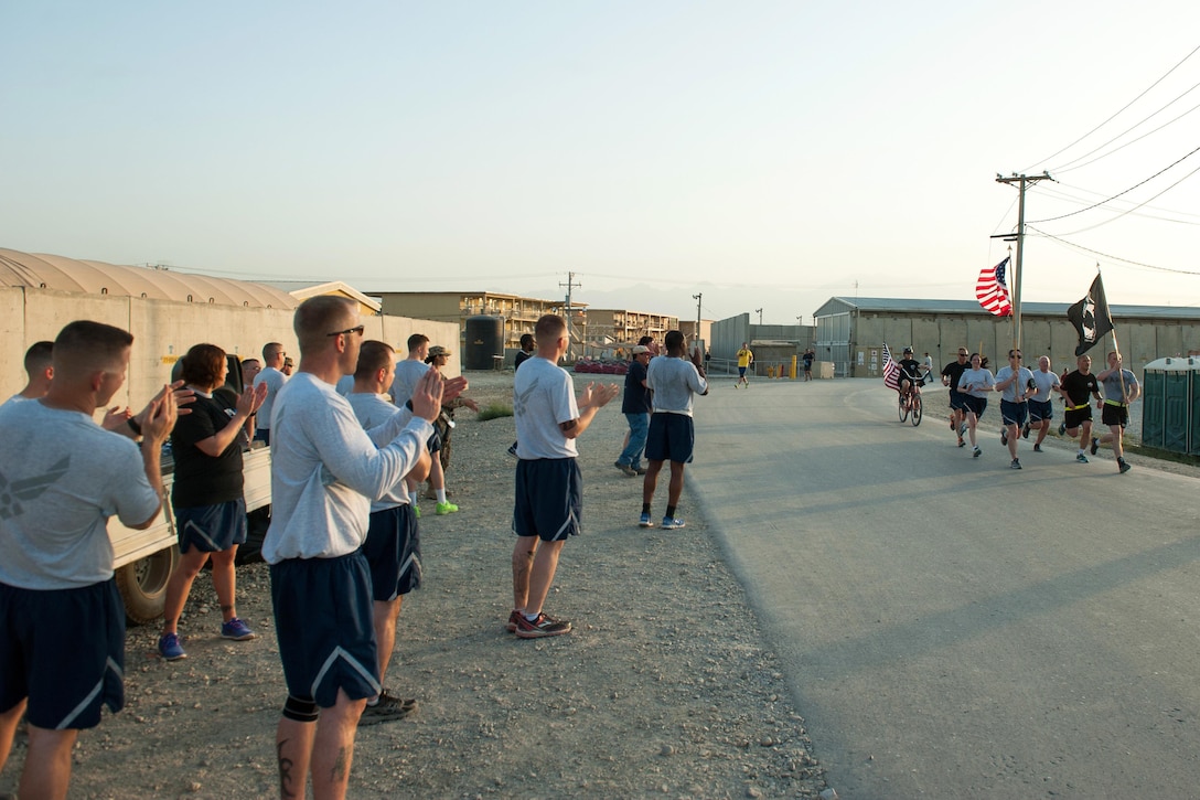 U.S. service members cheer as runners complete the final lap of a run to honor prisoners of war and those missing in action on Bagram Airfield, Afghanistan, Sept. 4, 2015. U.S. Air Force photo by Tech. Sgt. Joseph Swafford