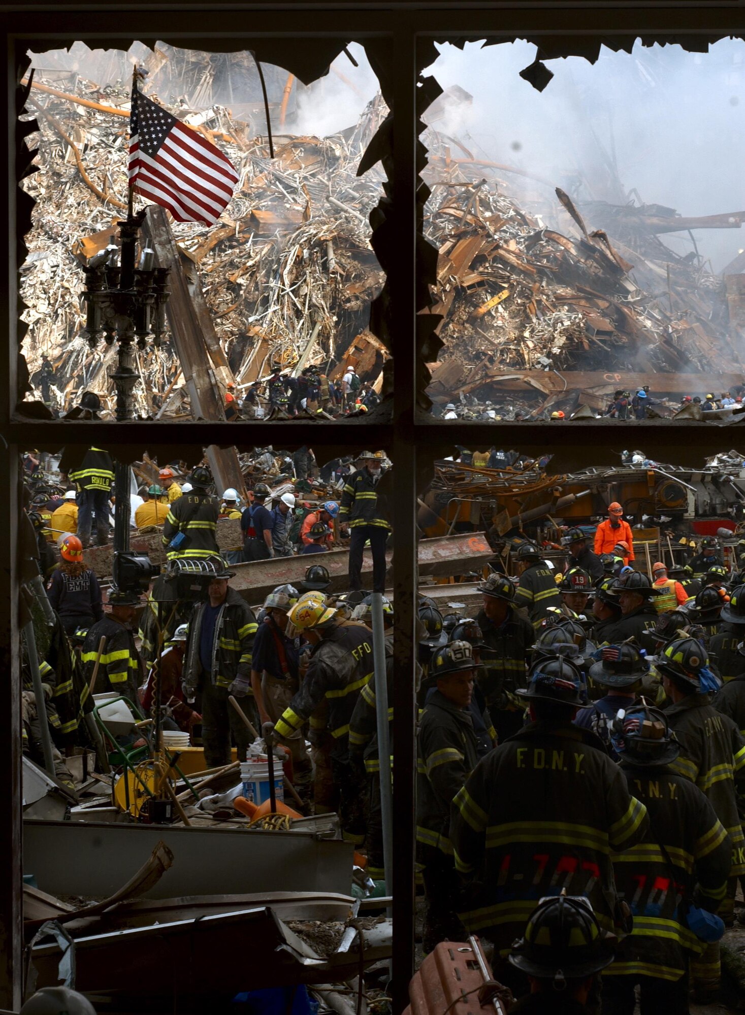 New York City firemen walk past the American flag as they work their way toward the heart of the devastation that was once the World Trade Center. (U.S. Navy Photo/Journalist 1st Class Preston Keres)