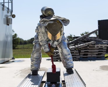 A competitor in the firefighter combat challenge portion of the 2015 Battle of the Badges hits a sled with a sledgehammer Sept. 12 at the Joint Base San Antonio-Randolph Camp Talon Fire Training Area. The firefighter combat challenge tested members of both parties with an obstacle course that included carrying gear up three flights of stairs, hoisting a bundle of hose from the ground with a rope, dragging a weighted dummy and hitting a target with a charged fire hose.