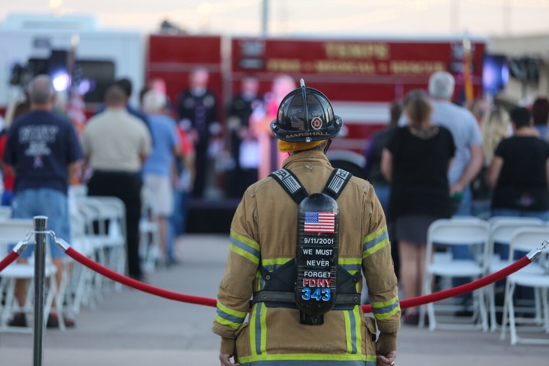 Bill Marshall, firefighter, listens to the roll call during a 9/11 remembrance ceremony at the Healing Field in Tempe Town Lake, Ariz., Sept. 11, 2015, during Marine Week Phoenix. Marine Week Phoenix is a chance for residents of the greater Phoenix area to connect with Marines, sailors, veterans and their families from different generations.