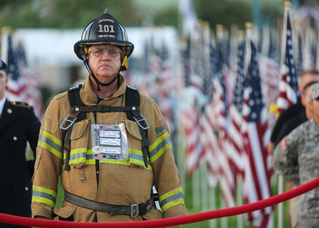 Bill Marshall, firefighter, listens to the roll call during a 9/11 remembrance ceremony at the Healing Field in Tempe Town Lake, Ariz., Sept. 11, 2015, during Marine Week Phoenix. Marine Week Phoenix is a chance for residents of the greater Phoenix area to connect with Marines, sailors, veterans and their families from different generations.