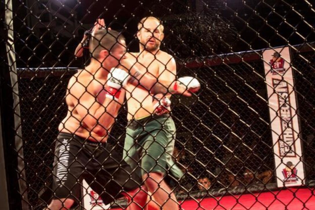 Jared Torgeson and Mitch Whitesel exchange punches during Leatherneck IV, MMA Fight Night Live aboard Camp Lejeune, N.C., Sept. 2, 2015. Marines gathered at Goettge Memorial Field House to watch nine professional fights and meet special guest five-time UFC Champion and UFC Hall of Famer, Randy Couture. (U.S. Marine Corps photo by Lance Cpl. Aaron Kane Fiala/Released)