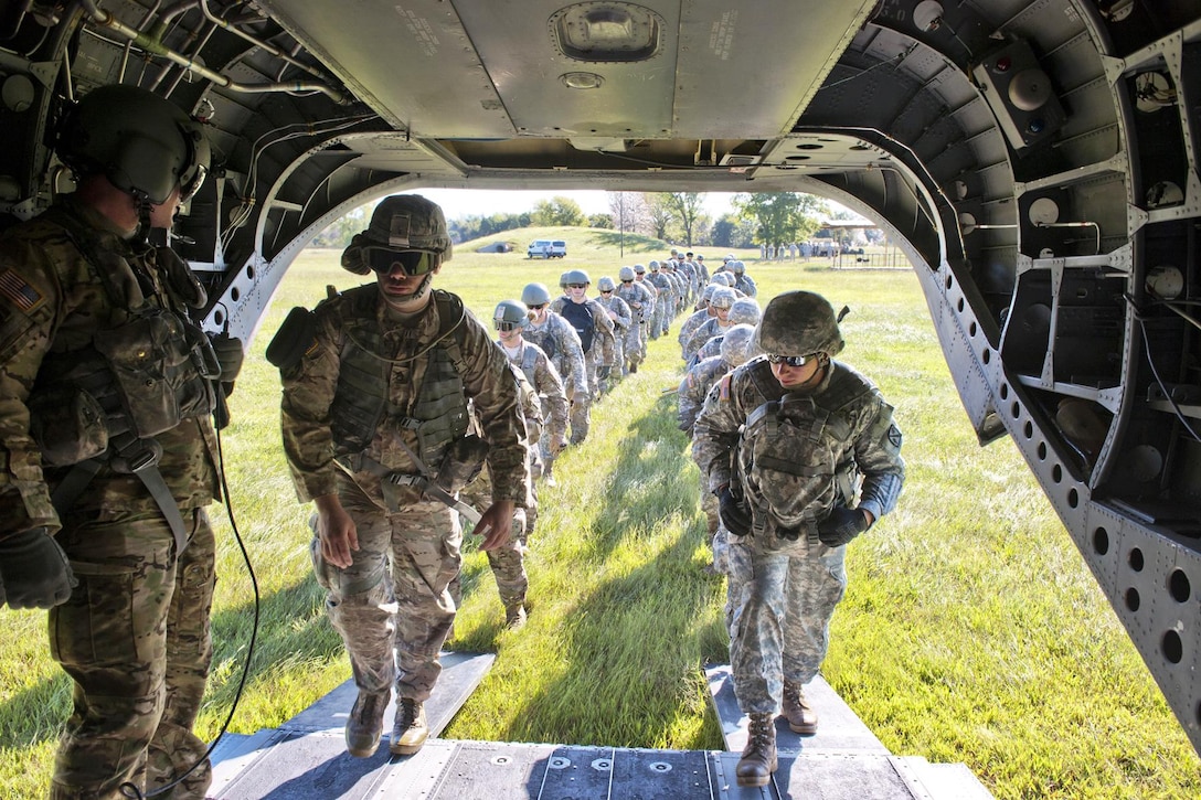 Oklahoma Army National Guardsmen board a CH-47 Chinook helicopter during training exercises at Camp Gruber, Okla., Sept. 12, 2015. The training included airborne insertions and extractions, room clearing and hand grenade exercises. Oklahoma National Guard photo by Army Maj. Geoff Legler