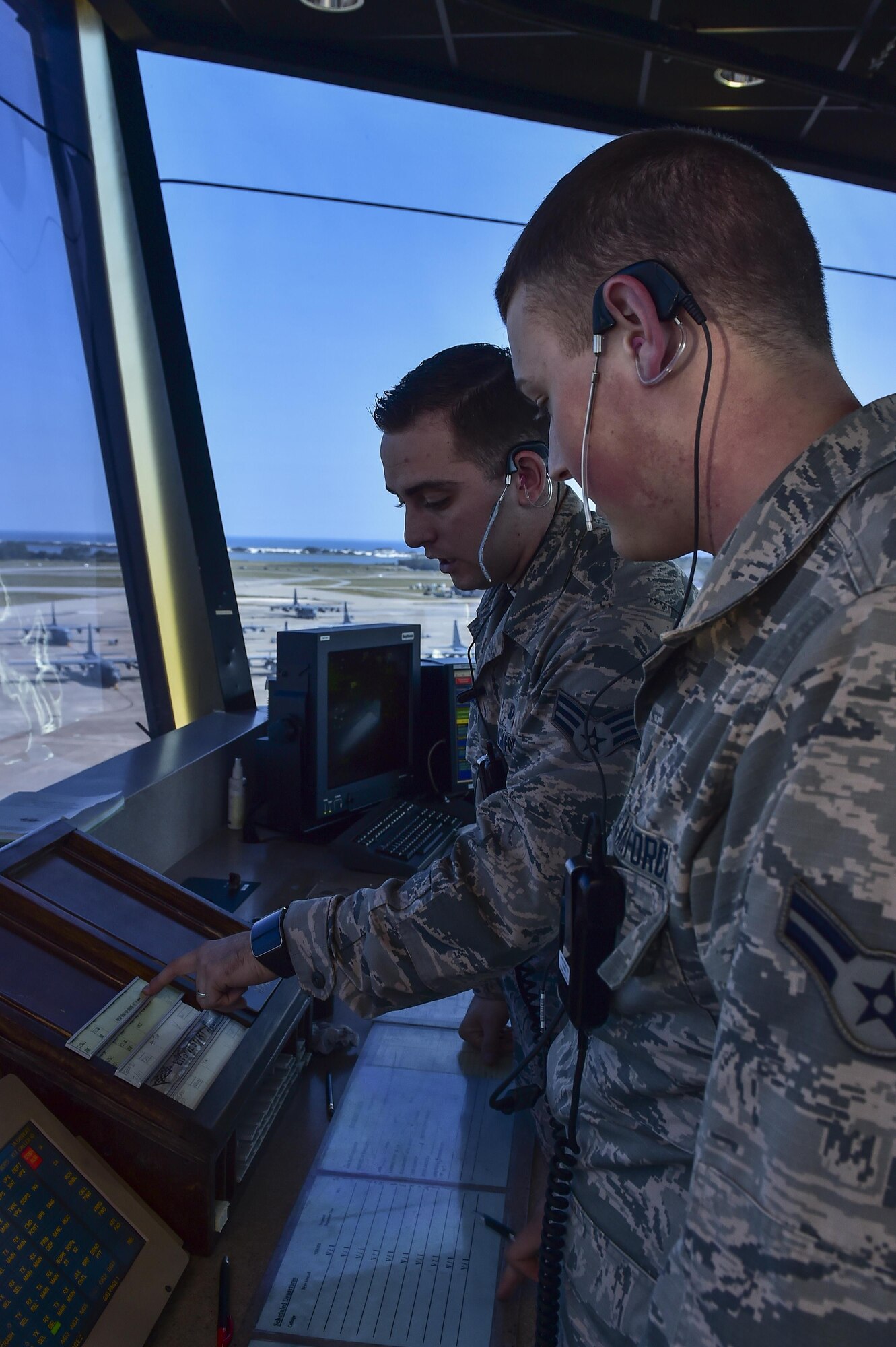 Senior Airman Justin Barabash, 1st Special Operations Support Squadron air traffic controller, trains Airman 1st Class Phillip Allman how to organize and track aircraft flight plans at Hurlburt Field, Fla., August 26, 2015. Air traffic controllers are responsible for all aircraft traffic on the ground and in the air. (U.S. Air Force photo/Senior Airman Jeff Parkinson)