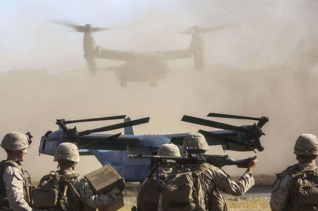 Marines watch as an MV-22 Osprey lands during an aircraft and personnel recovery mission as part of a realistic urban training exercise on Fort Hunter Liggett, Calif., Sept. 1, 2015. The Marines are assigned to the ground combat element of the 13th Marine Expeditionary Unit. U.S. Marine Corps photo by Sgt. Paris Capers