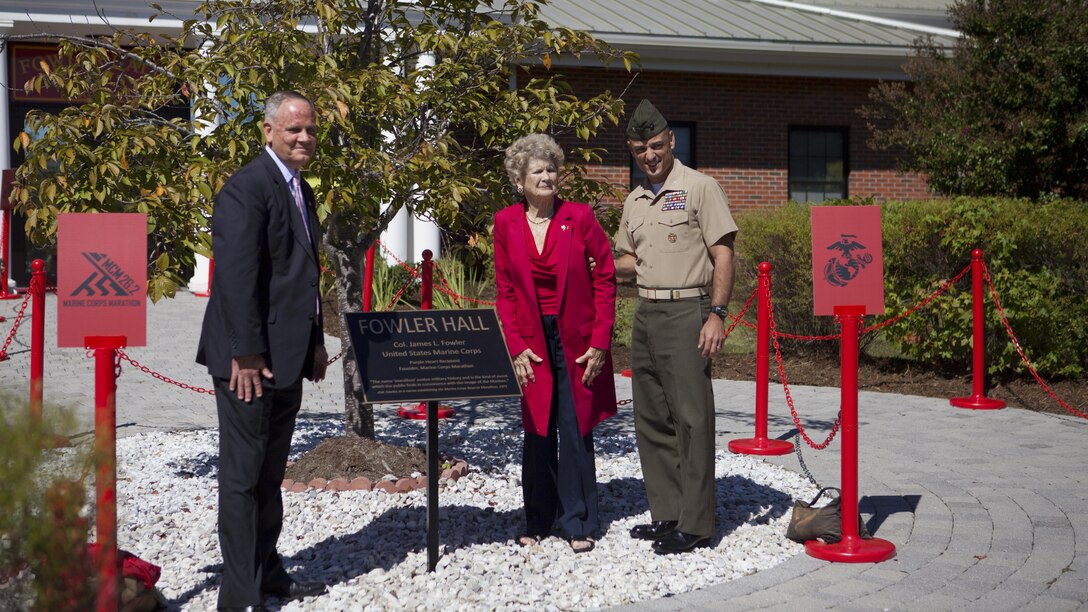 Betsy Fowler, widow of Col. James Fowler founder of the Marine Corps Marathon, poses with guests after unveiling the plaque at the Marine Corps Marathon building dedication at Marine Corps Base Quantico, Virginia, Sept. 14, 2015. James Fowler founded the Marine Corps Marathon in 1975, while still serving at Headquarters Marine Corps, to help create a community of goodwill between the Marine Corps and the civilian populace. 