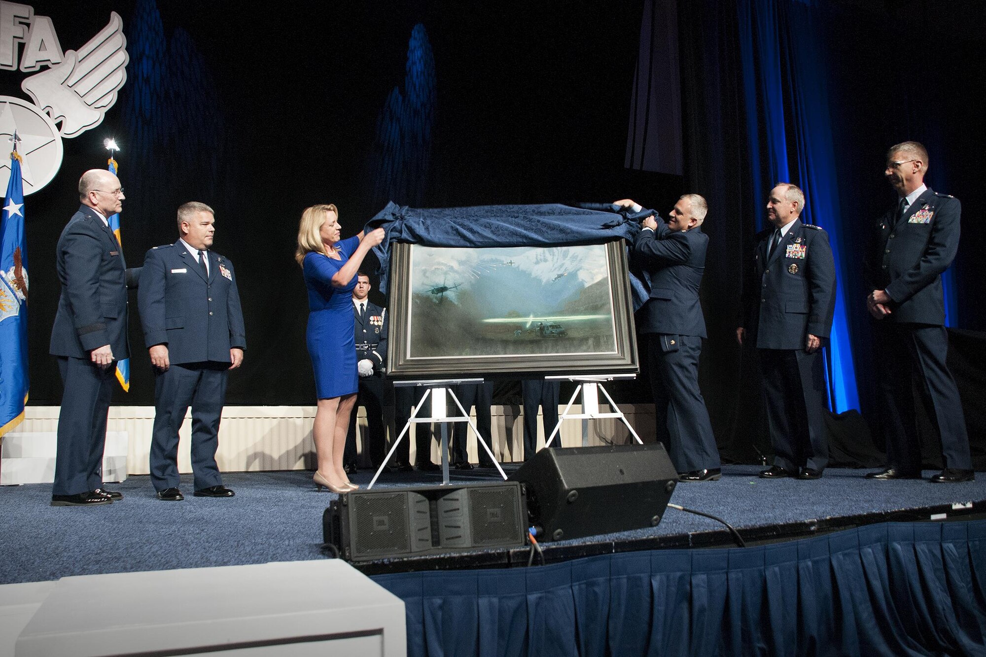 Air Force Secretary Deborah Lee James and Maj. Warren Neary, the Air Force Space Command historian and an Air Force Art Program artist, unveil the painting “That Others May Live” during the Air Force Association Air and Space Conference and Technology Exposition, Washington, D.C., Sept. 14, 2015. “That Others May Live” documents the rescue of Marcus Luttrell, a Navy SEAL, in June 2005 by Reservists from the 920th Rescue Wing at Patrick Air Force Base, Florida. The rescue was dramatized in the movie “The Lone Survivor.” (U.S. Air Force photo/Staff Sgt. Kat Justen)