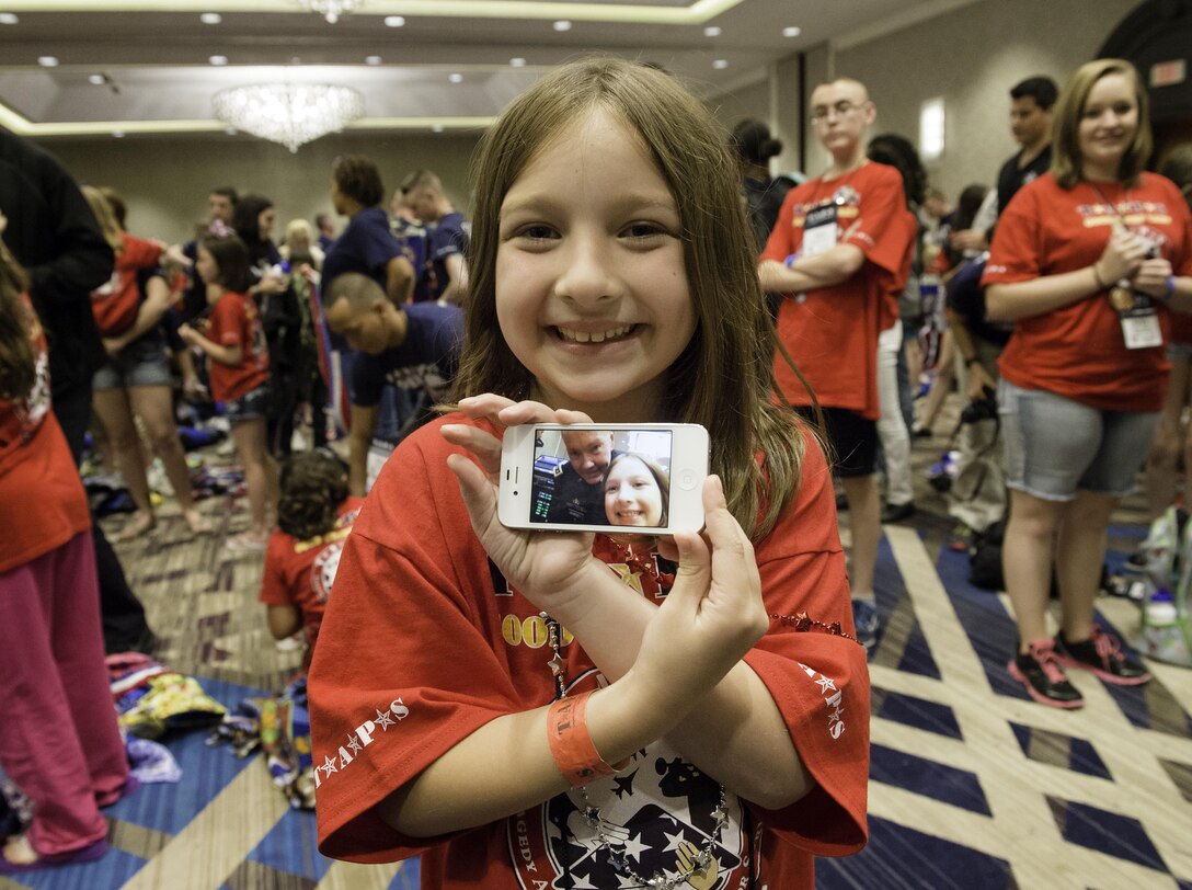 A child at the annual Tragedy Assistance Program for Survivors, or TAPS, National Military Survivor Seminar and Good Grief Camp for children in Arlington, Va., shows off a selfie with guest speaker Army Gen. Martin E. Dempsey, chairman of the Joint Chiefs of Staff, May 23, 2014. DOD photo by U.S. Army Staff Sgt. Sean K. Harp