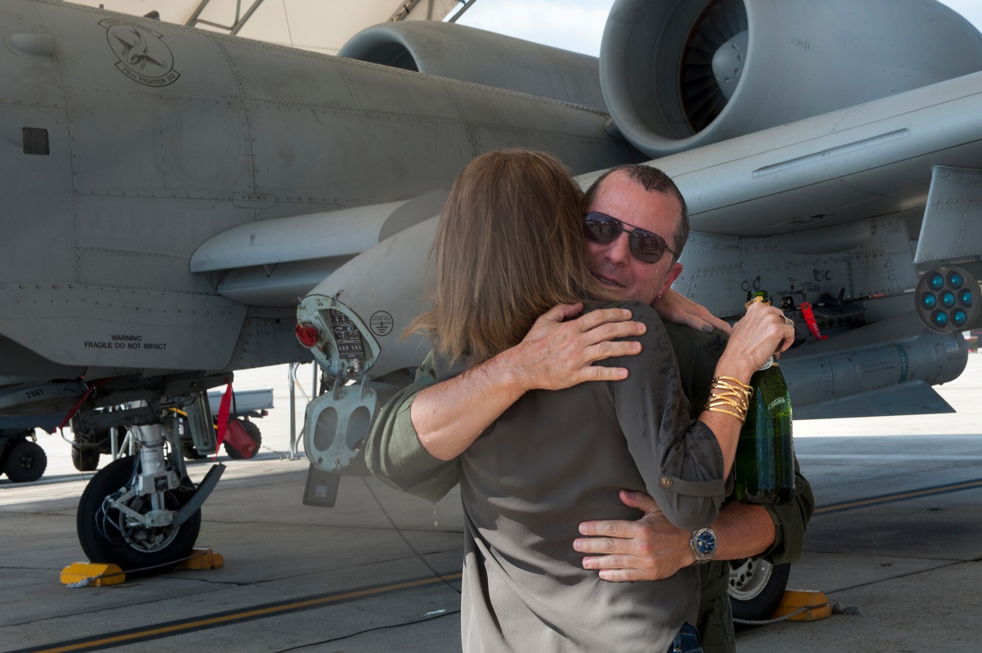 U.S. Air Force Col. James Travis, 476th Fighter Group commander, and his wife, Lisa, hug after his fini-flight Sept. 11, 2015, at Moody Air Force Base, Ga. Travis relinquished command of the 476th FG on Sept. 13, and will be assigned to the Pentagon for his first non-flying duty after 26 years in the Air Force.  (U.S. Air Force photo by Airman 1st Class Kathleen D. Bryant/Released)