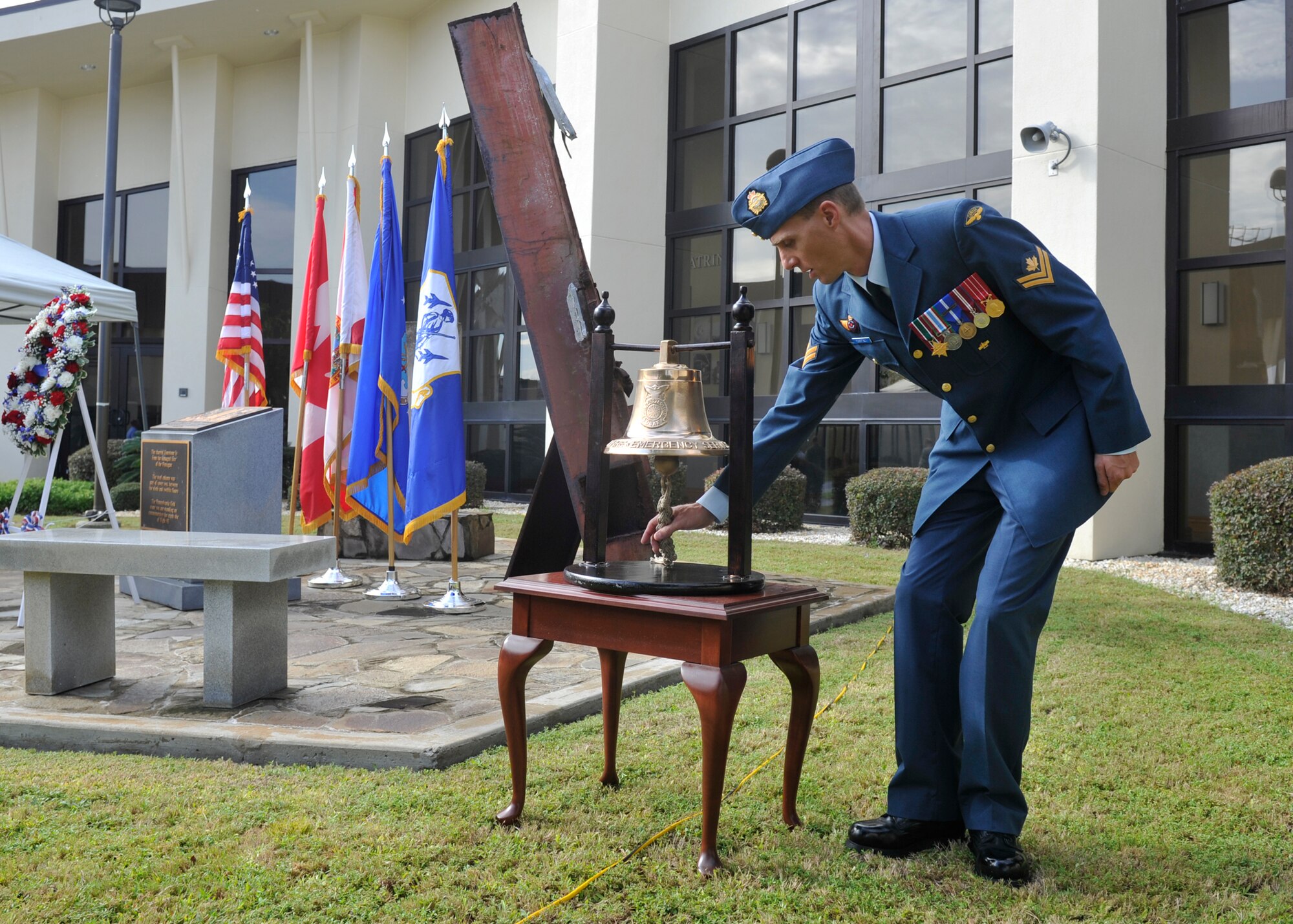 Royal Canadian Air Force MCpl Craig Robertson, 101st Air Communications Squadron, tolls the ceremonial bell from the 325th Fighter Wing Fire Department during the 9/11 remembrance ceremony at the 601st Air Operations Center. The ceremony was held to honor and remember all who were affected by the tragic events of that day. (Air Force photo released/Airman 1st Class Sergio Gamboa)