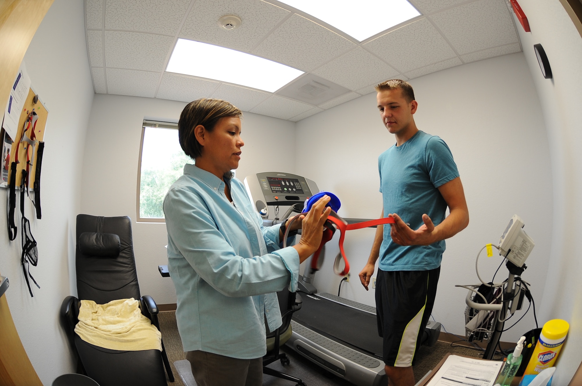 Lana R. Fred, Davis-Monthan Air Force Base Health and Wellness Center program coordinator, instructs U.S. Air Force Senior Airman Yevgeniy Sokolov, 355th Aircraft Maintenance Squadron crew chief, how to wear a VO2 max facemask at Davis-Monthan AFB, Ariz., Sept. 2, 2015. The mask covers both the mouth and nose while it measures the body’s oxygen intake though a tube connected to both the facemask and computer. (U.S. Air Force photo by Airman 1st Class Ashley N. Steffen/Released)