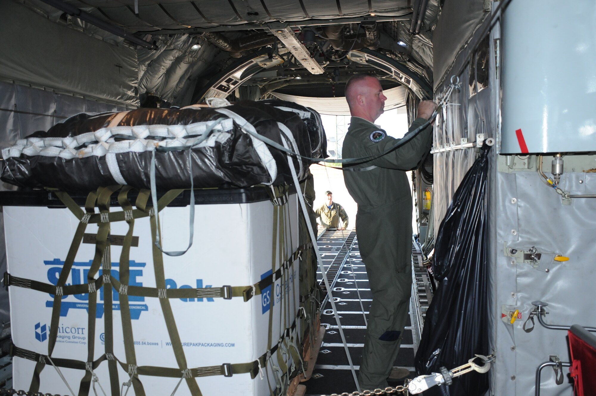 Staff Sgt. Pat Englishby (front), loadmaster, 328th Airlift Squadron, secures an palette inside a C-130 Hercules aircraft while Senior Airman Ken Zidell, loadmaster, 328 AS assists, at Ramstein Air Base, Germany, on Aug. 21, 2015. Englishby and Zidell were participating in Exercise Swift Response, a multinational training exercise. (U.S. Air Force photo by Staff Sgt. Matthew Burke/released)