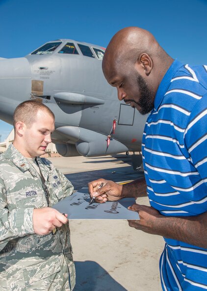 Shaquille O’Neil, former professional basketball player, signs a name plaque held by 2nd Lt. Tyler Roten, 5th Maintenance Squadron fabrication flight commander, at Minot Air Force Base, N.D., September 8, 2015.  O’Neil spoke to Airmen at the base theater about his father, a former Army drill sergeant, and how the military’s values shaped his success. (U.S. Air Force photo/ Airman 1st Class Justin T. Armstrong)