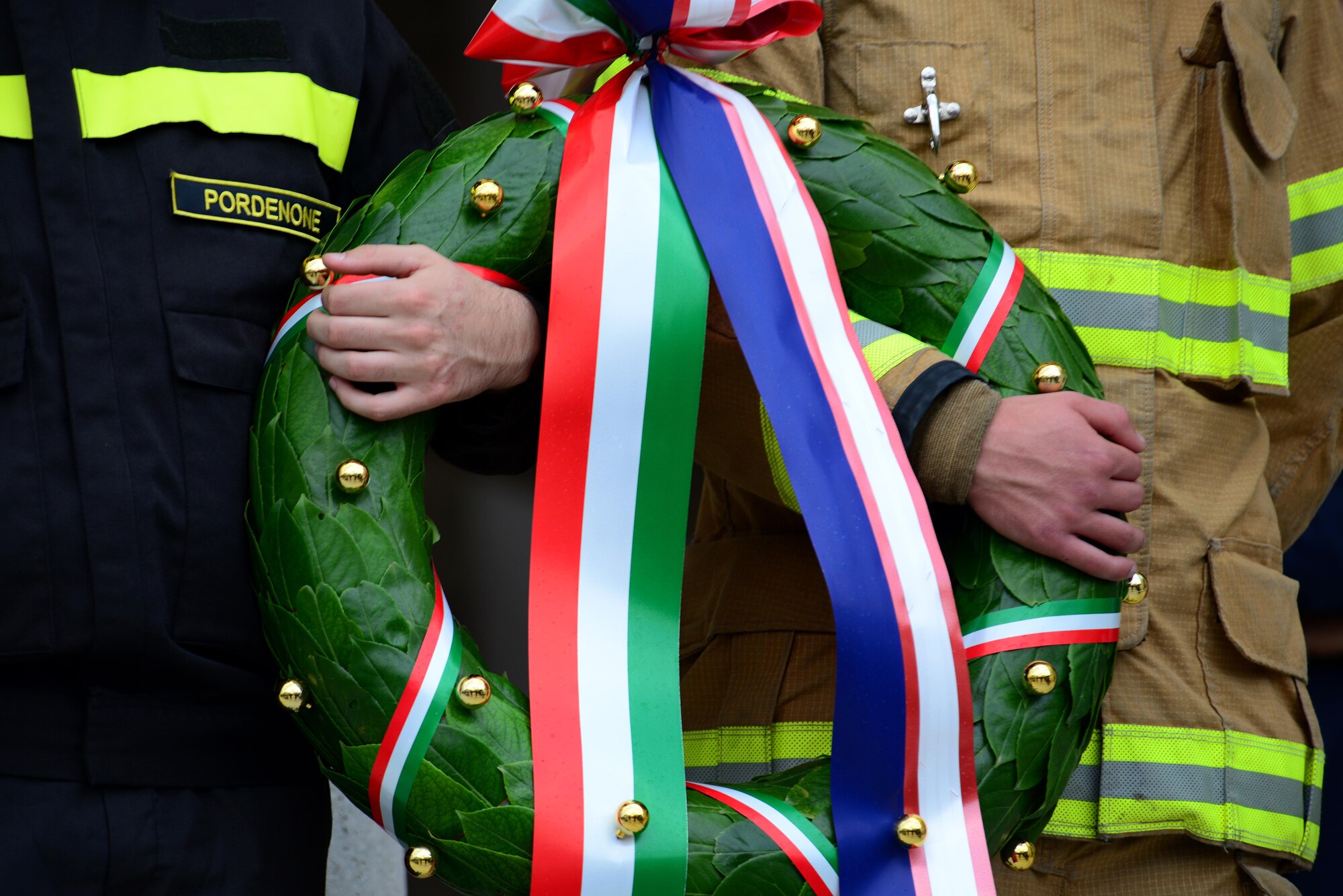 An Italian and U.S. Air Force firefighter hold a wreath during a ceremony at the American-Italian Friendship Festival, on Sept. 12, 2015, in Spilimbergo, Italy. The festival allowed Team Aviano an opportunity to strengthen bonds with their host nation community. The event also included several demonstrations, food, sports tournaments, music and a ceremony. (U.S. Air Force photo by  Staff Sgt. Evelyn Chavez/Released)