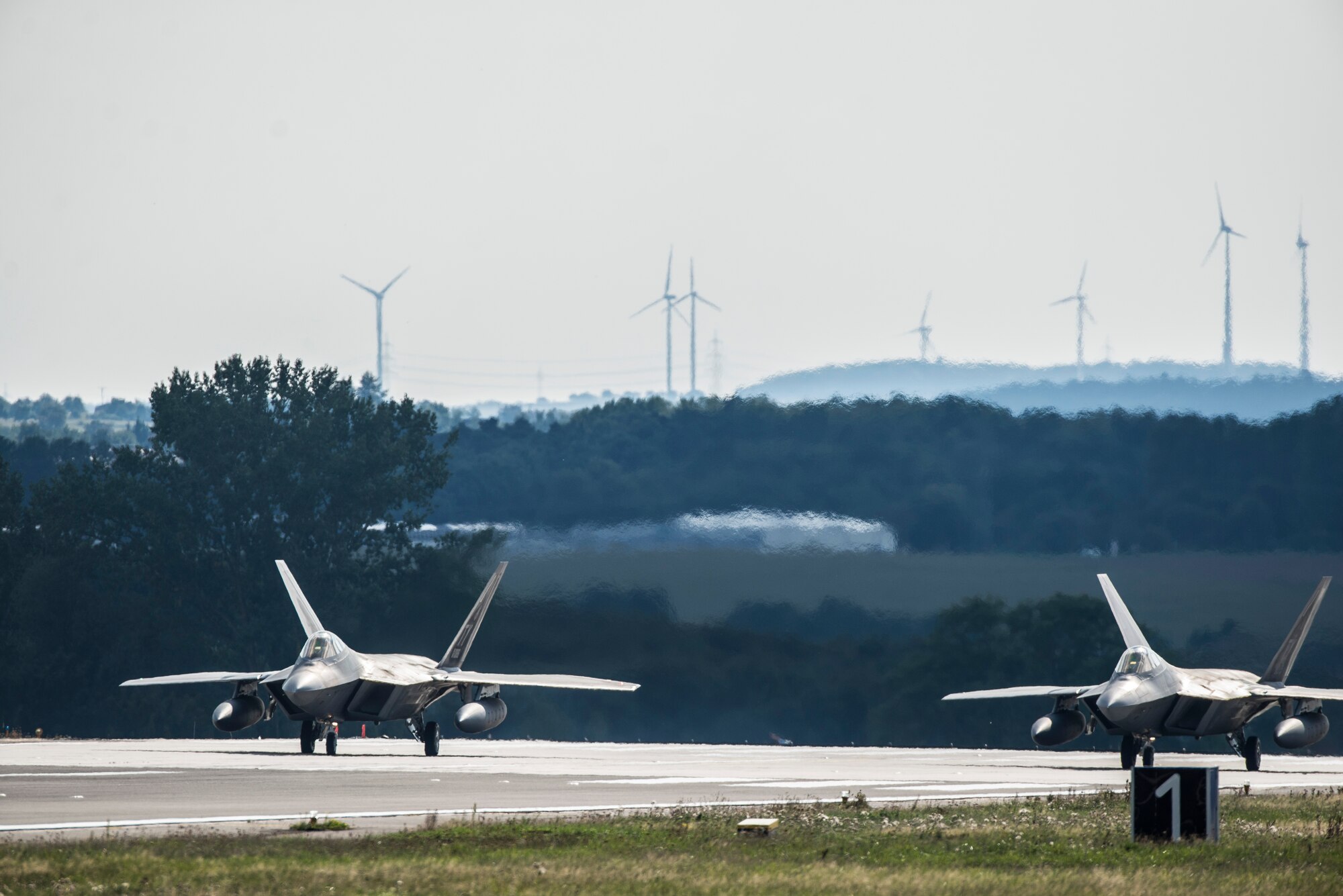 U.S. Air Force F-22 Raptor fighter pilots assigned to the 95th Fighter Squadron at Tyndall Air Force Base, Fla., prepare for takeoff on the runway Sept. 11, 2015, at Spangdahlem Air Base, Germany. The F-22s conducted dissimilar air training with other fighter squadrons in U.S. Air Forces in Europe to include F-15 Eagle and F-16 Fighting Falcon fighter aircraft. The F-22 Raptors also forward deployed for short periods of time to non-U.S. NATO bases. The USAF’s forward presence in Europe allows training with U.S. allies and partners to develop and improve regional security. (U.S. Air Force photo by Staff Sgt. Christopher Ruano/Released)