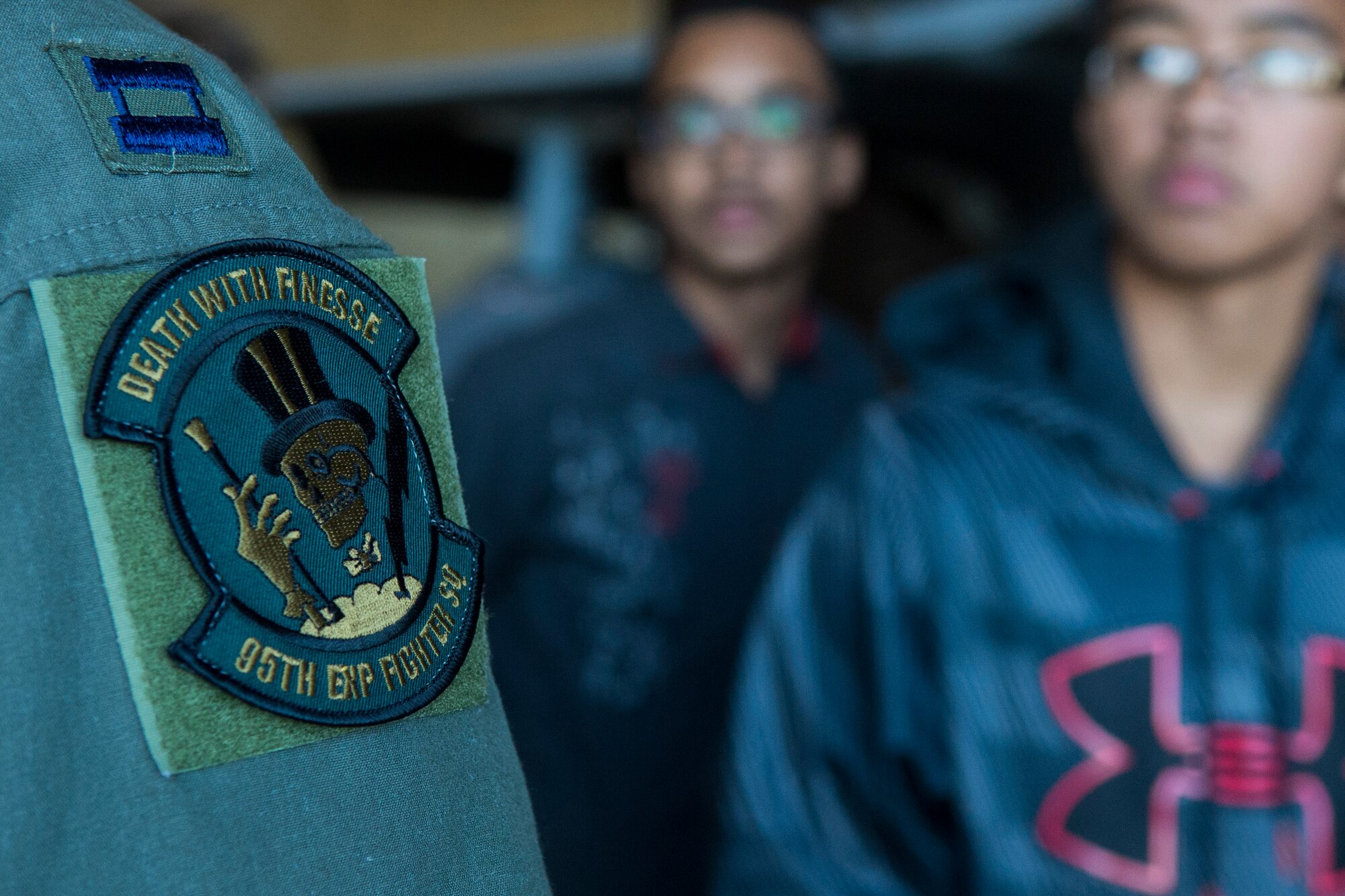 A 95th Fighter Squadron patch is displayed on the shoulder of U.S. Air Force Capt. Michael Sayers, 95th FS F-22 Raptor fighter aircraft pilot, during a Junior ROTC tour of an F-22 in a hardened aircraft shelter at Spangdahlem Air Base, Germany, Sept. 10, 2015. The 95th FS, located at Tyndall Air Force Base, Fla., deployed four F-22s to Spangdahlem as part of the European Reassurance Initiative. (U.S. Air Force photo by Airman 1st Class Luke Kitterman/Released)
