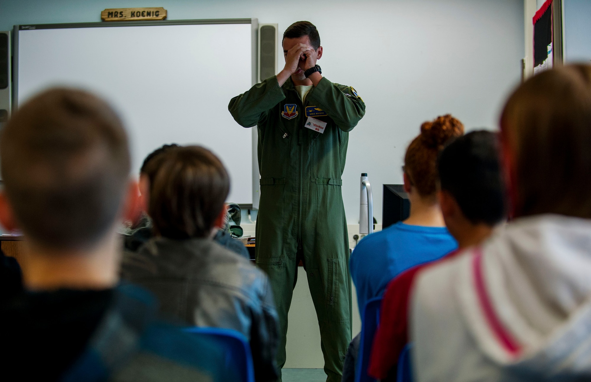 U.S. Air Force Capt. Michael Sayers, a 95th Fighter Squadron F-22 Raptor fighter pilot, explains tunnel vision to Spangdahlem Middle School students during a visit on Spangdahlem Air Base, Germany, Sept. 9, 2015. Two 95th FS pilots visited the school to inform students on the aspects of their job and expose them to the career field. The 95th FS, from Tyndall Air Base, Fla., sent the F-22 Raptors to Spangdahlem on their first training mission to Europe as part of the European Reassurance Initiative, which provides support to NATO allies and partners in Europe. (U.S. Air Force photo by Airman 1st Class Timothy Kim/Released)