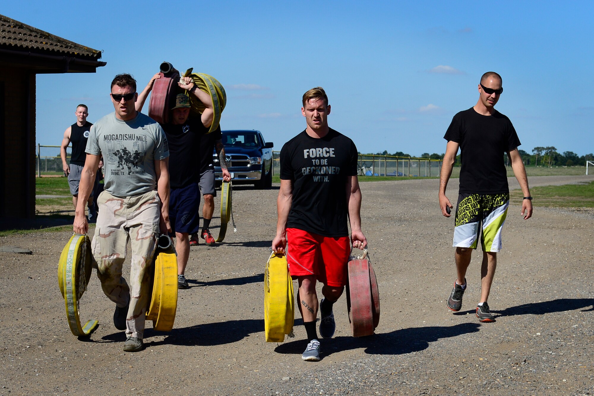 Team Lakenheath carries fire hoses during a relay event at the second annual Battle of the Badges at Royal Air Force Lakenheath, England, Sept. 10, 2015. The competition between the first responders of RAFs Lakenheath and Mildenhall is intended as an opportunity for them to remember and commemorate how first responders came together during the 9/11 attacks. (U.S. Air Force photo by Airman 1st Class Erin R. Babis/Released)