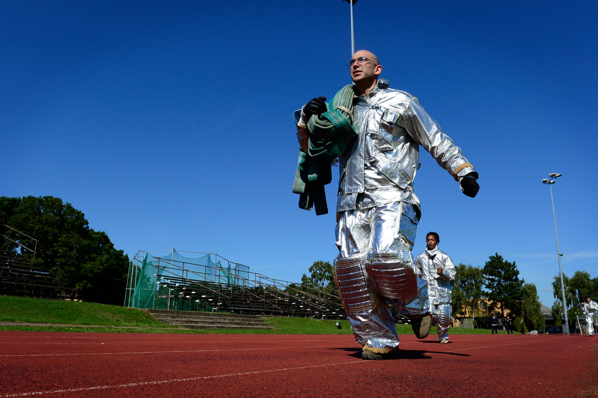 Members of team Mildenhall’s security forces squadron run half a mile in firefighting gear as part of a relay event during the second annual Battle of the Badges at Royal Air Force Lakenheath, England, Sept. 10, 2015. The competition between the first responders of RAFs Lakenheath and Mildenhall is intended as an opportunity for them to remember and commemorate how first responders came together during the 9/11 attacks. (U.S. Air Force photo by Airman 1st Class Erin R. Babis/Released)