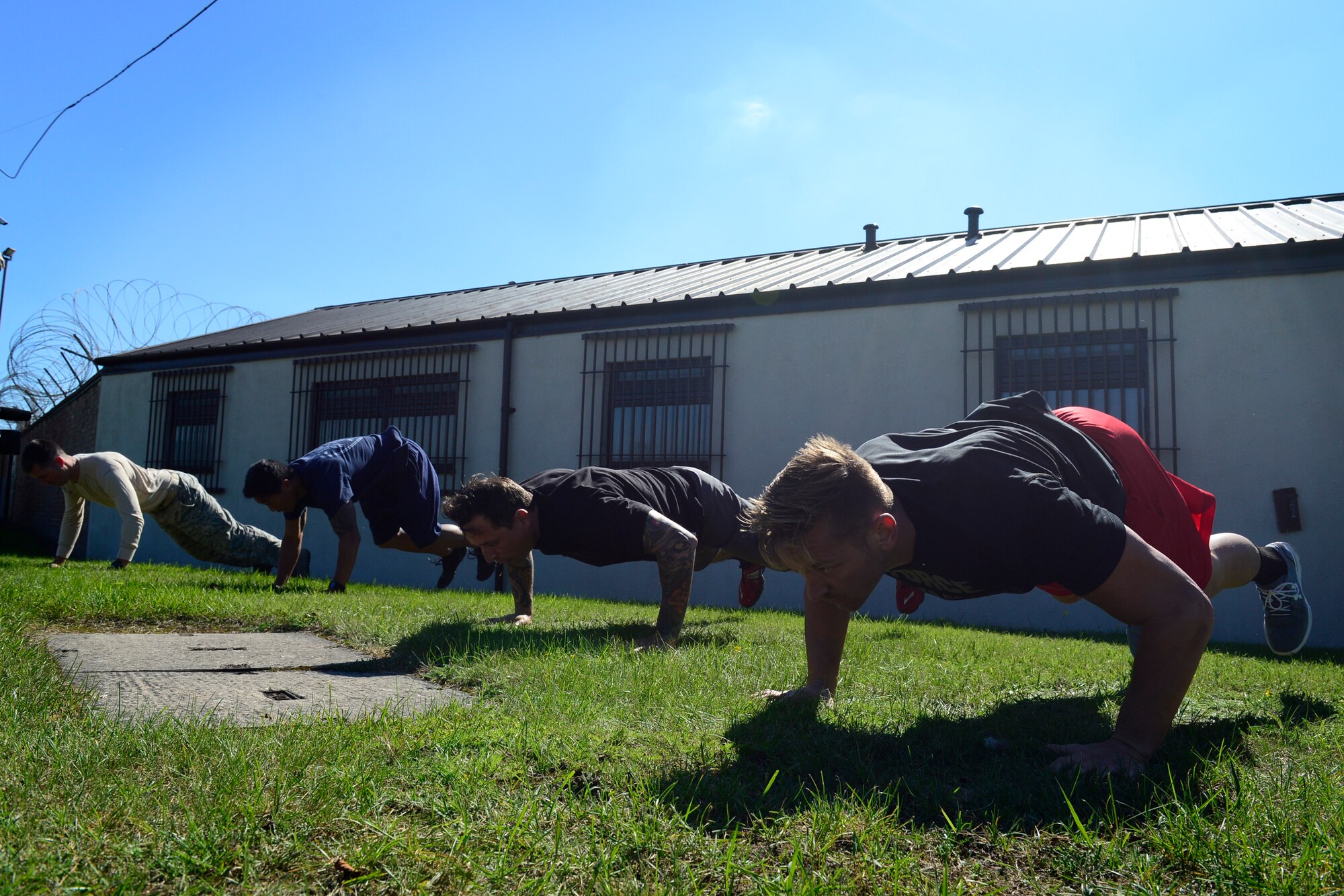 Teams Lakenheath and Mildenhall perform burpees during the second annual Battle of the Badges at Royal Air Force Lakenheath, England, Sept. 10, 2015. The competition between the first responders of RAFs Lakenheath and Mildenhall is intended as an opportunity for them to remember and commemorate how first responders came together during the 9/11 attacks. (U.S. Air Force photo by Airman 1st Class Erin R. Babis/Released)