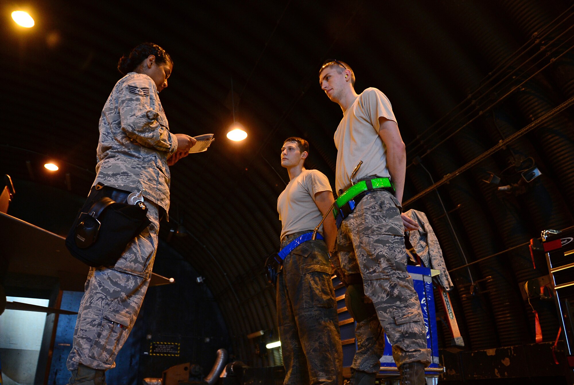 Staff Sgt. Jenean Fischer, 48th Aircraft Maintenance Squadron weapons load crew team chief, gives instruction to weapons load crew Airmen before a weapons standardization evaluation at Royal Air Force Lakenheath, England, July 14, 2015. Every month, weapons load crew Airmen are evaluated on their proficiency to become certified on any amount of munitions. (U.S. Air Force photo by Senior Airman Erin O’Shea/Released)