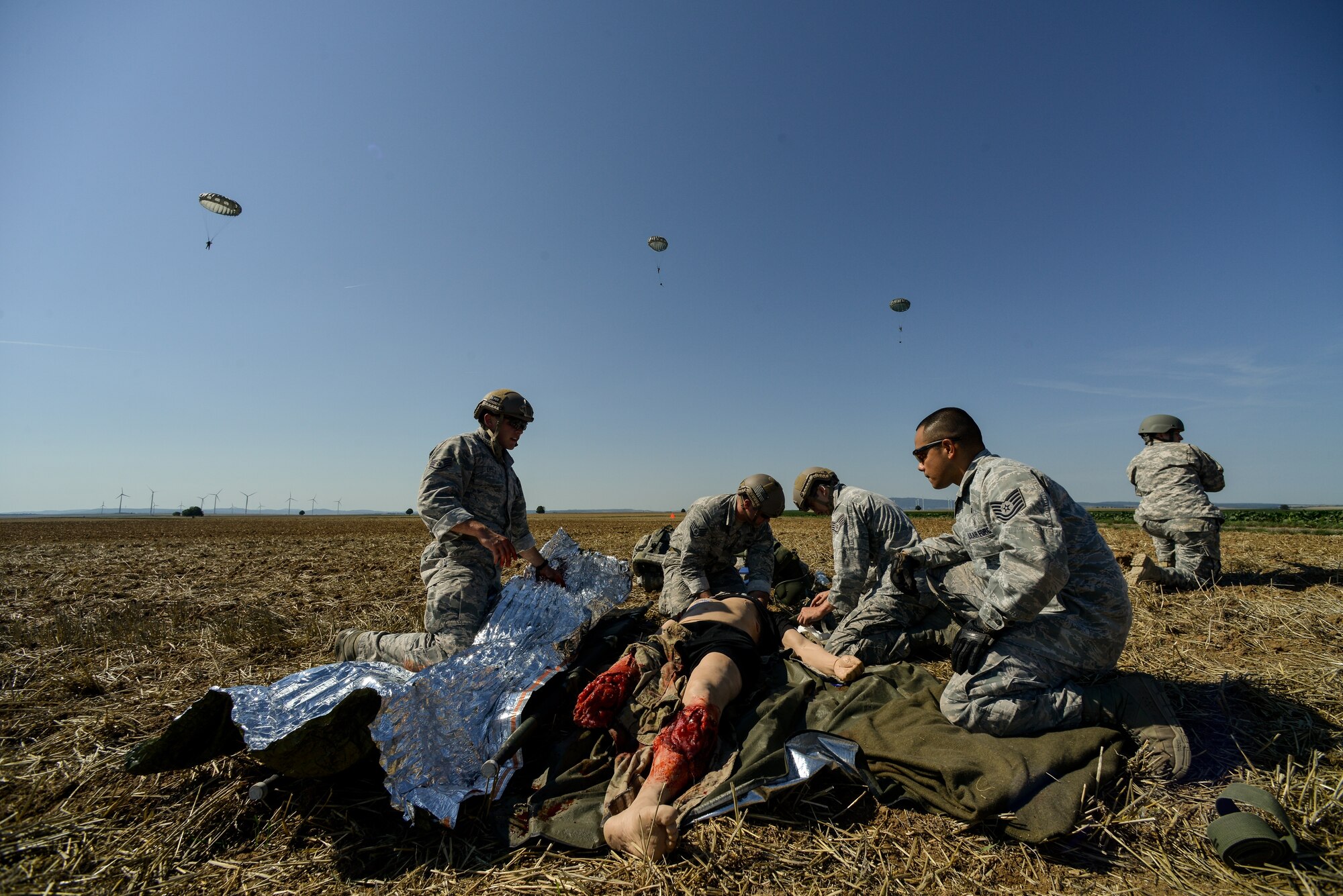 Airmen and Soldiers care for a simulated casualty at Alzey drop zone near Kaiserslautern, Germany, Aug. 31, 2015. More than 20 responders from the 435th Contingency Response Group and the U.S. Army 1/10th Special Forces Group responded to the simulated medical evacuation.  After treating the patient for life threatening wounds, the team transported him to a safe area. (U.S. Air Force photo/Senior Airman Nicole Sikorski)