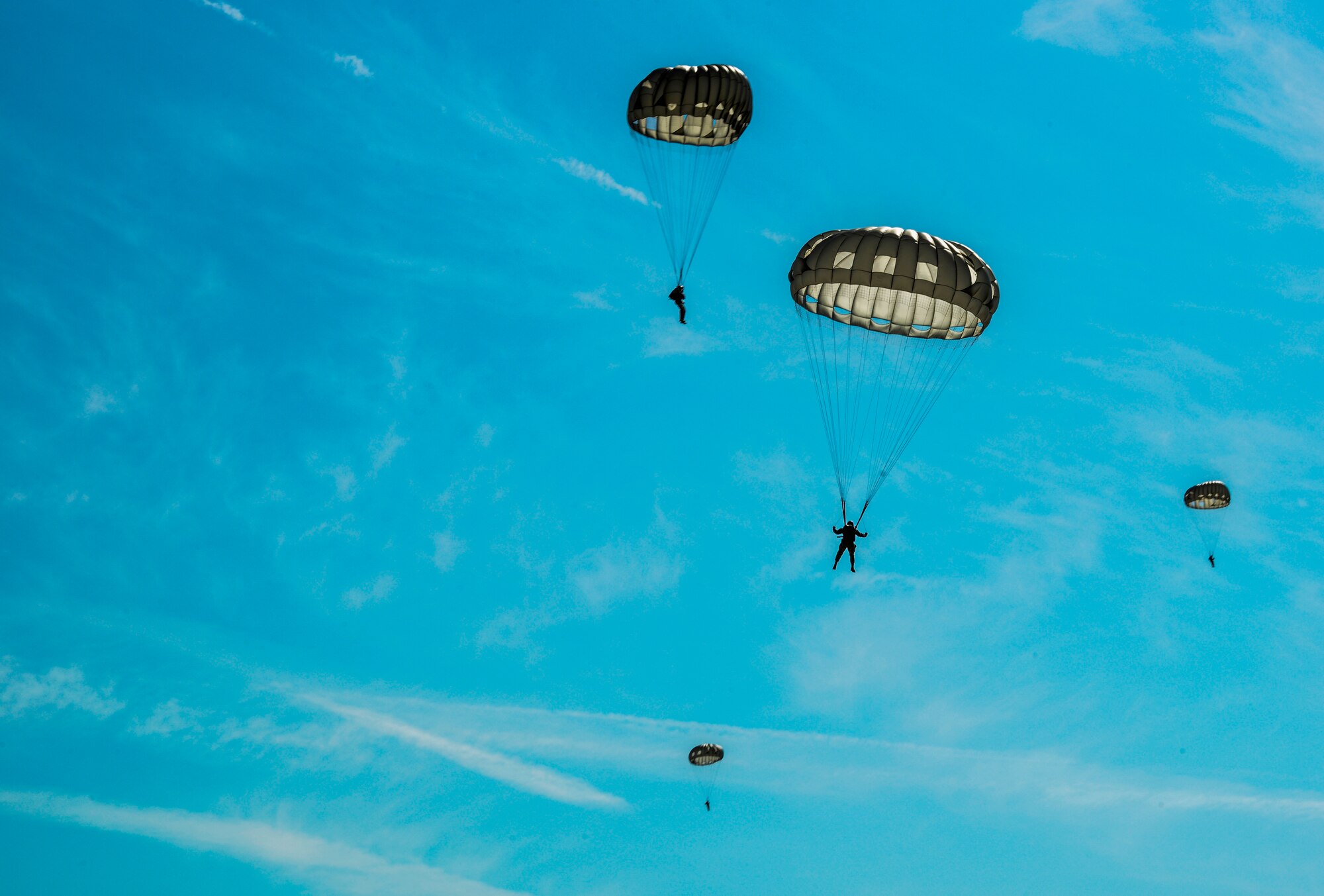 Airmen and Soldiers parachute over Alzey drop zone near Kaiserslautern, Germany, Aug. 31, 2015. Airmen and Soldiers participated in a medical portion of Tactical Combat Casualty Care, which tested their ability to jump from a C-130J Super Hercules and quickly arrive at an accident scene, where a simulated patient needed immediate care. (U.S. Air Force photo/Senior Airman Nicole Sikorski) 