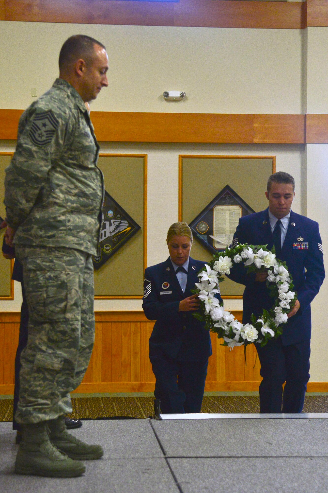 A wreath is laid during the 9/11 Remembrance Ceremony Sept. 11, 2015, in the Grizzly Bend at Malmstrom Air Force Base, Mont. Master Sgt. Sarah Edwards representing the Air Force Sergeants Association, and Staff Sgt. Kyler Pierce representing the Air Force Association, assisted Chief Master Sgt. Thomas Stiles, 341st Missile Wing command chief, in laying the wreath. (U.S. Air Force photo/Airman Daniel Brosam)
