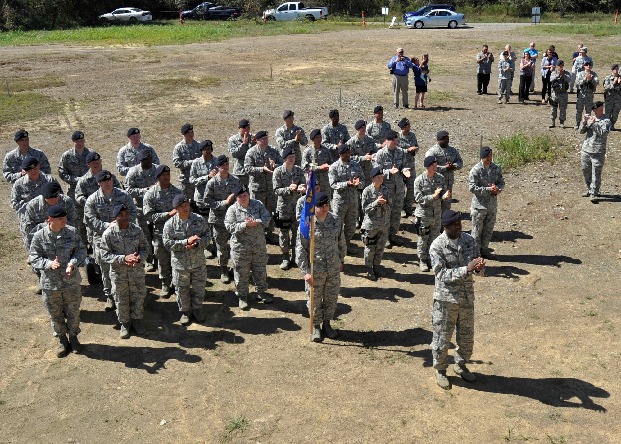Team Little Rock members applaud after two Defenders from the 19th Security Forces Squadron were awarded the Air Force Commendation Metal Sept. 14, 2015, at Military Operations Urban Terrain (MOUT) Village on Little Rock Air Force Base, Ark. Both members engaged and neutralized a threat protecting 17,000 base personnel and more than $3.8 billion in government assets June 15, 2015. (U.S. Air Force photo by Senior Airman Scott Poe)  