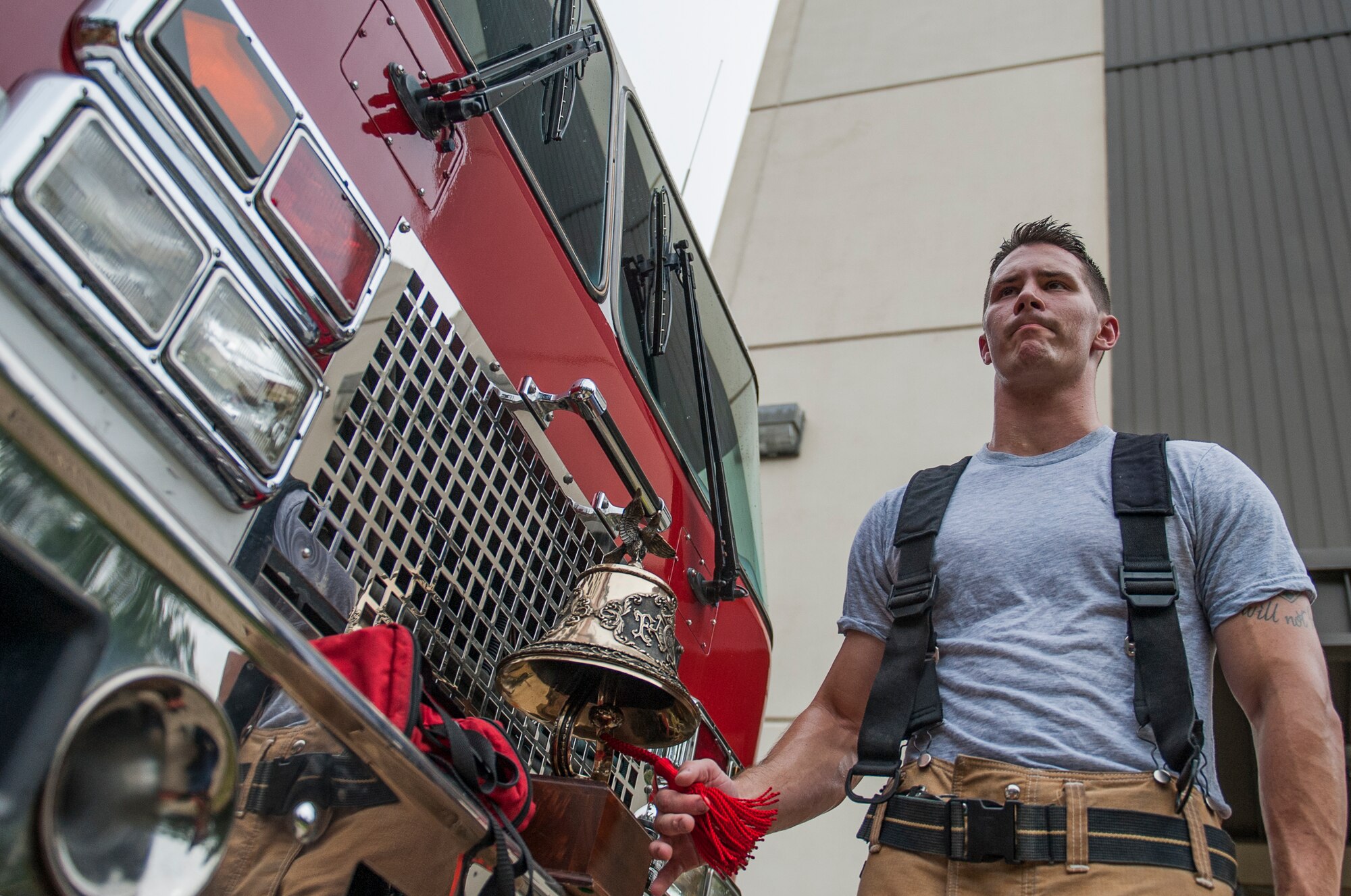 Senior Airman, Quinton Doss, the youngest member of the 96th Civil Engineer Squadron Fire Department, rings a bell during the annual 9/11 memorial tower climb at Eglin Air Force Base, Fla. Sept. 11.  Approximately 45 firefighters climbed 13 flights of steps with a name tag for each of the 343 firefighters who lost their lives 14 years ago. After reaching the top of the air traffic control tower, each name was recited and attached to a commemorative display board. The event closed with traditional bell rings and pauses between each ring to honor the 9/11 heroes. (U.S. Air Force photo/Ilka Cole)
