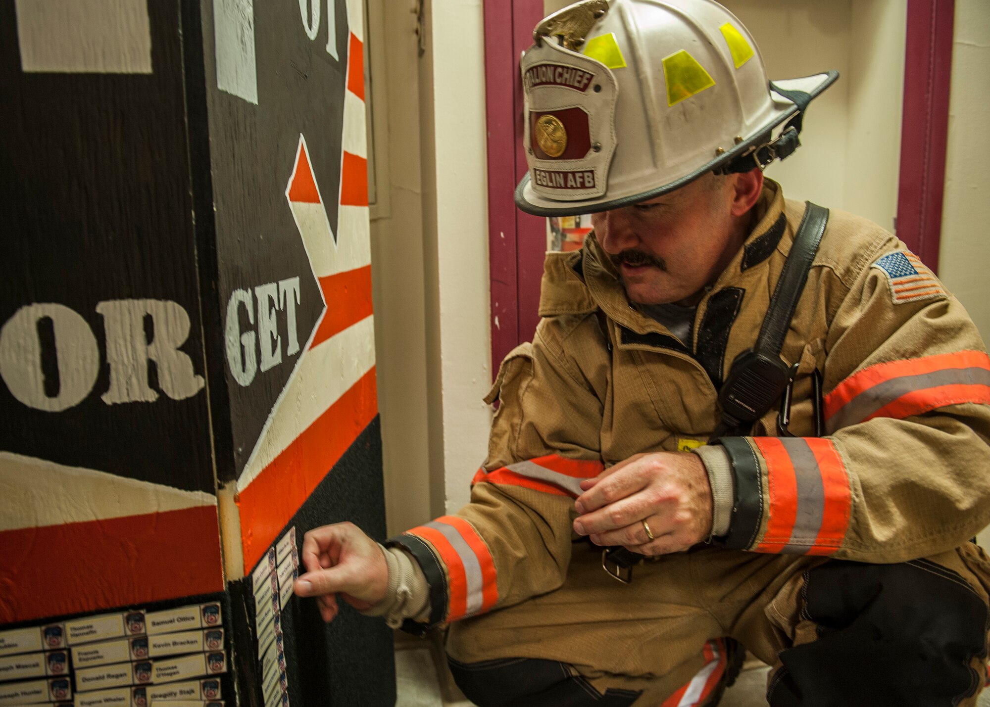 Charles Arnold, 96th Civil Engineer Squadron battalion fire chief, places a name tag on a display board during the annual 9/11 memorial tower climb at Eglin Air Force Base, Fla. Sept. 11. Approximately 45 firefighters climbed 13 flights of steps with a name tag for each of the 343 firefighters who lost their lives 14 years ago. After reaching the top of the air traffic control tower, each name was recited and attached to a commemorative display board. The event closed with traditional bell rings and pauses between each ring to honor the 9/11 heroes. (U.S. Air Force photo/Ilka Cole) 