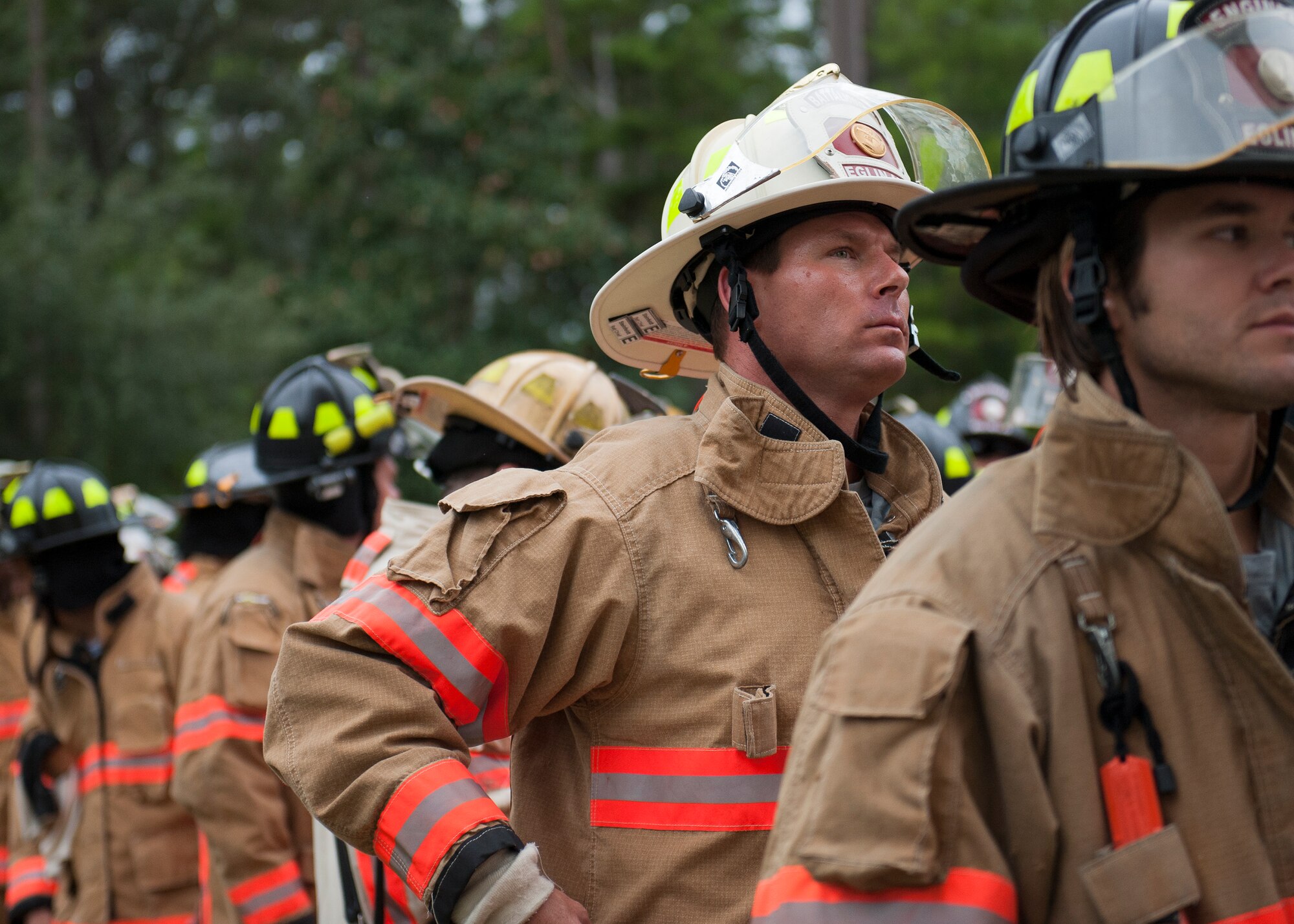 Firefighters from the 96th Civil Engineer Squadron, form a line to enter the air traffic control tower during the annual 9/11 memorial tower climb at Eglin Air Force Base, Fla. Sept. 11. 
Approximately 45 firefighters climbed 13 flights of steps with a name tag for each of the 343 firefighters who lost their lives 14 years ago. After reaching the top of the air traffic control tower, each name was recited and attached to a commemorative display board. The event closed with traditional bell rings and pauses between each ring to honor the 9/11 heroes. (U.S. Air Force photo/Ilka Cole)
