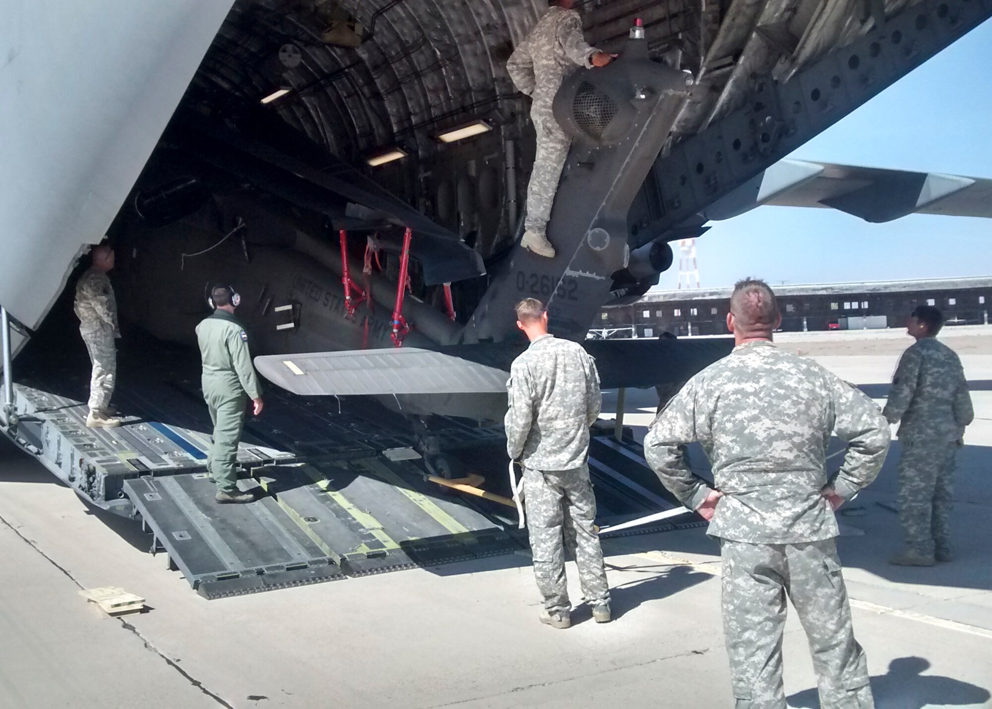 Two NCOs from the 412th Logistics Readiness Squadron and members of an Army Blackhawk crew assisted in preparing the helicopter for transport. (U.S. Air Force photo by Rebecca Amber)