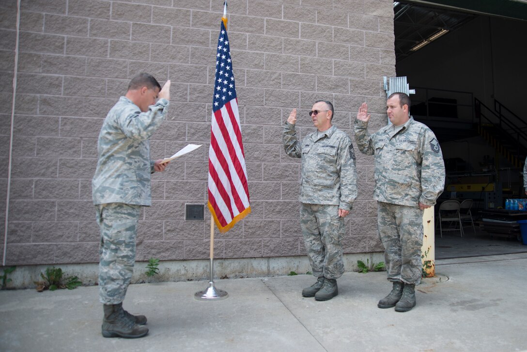 Capt. Frank King administers the oath of re-enlistment to uncle and cousin, Chief Master Sgt. Craig Sanborn and Master Sgt. Chirs Sanborn at the 158th Fighter Wing in South Burlington, Vt., Aug. 6, 2015. It is a rare occasion at the Vermont Air National Guard that three family members are involved in such an honorable event. (U.S. Air National Guard photo by Airman 1st Class Jeffrey Tatro)
