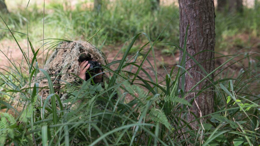 Japan Ground Self-Defense Force Sgt. Akito Yagi looks through binoculars at the target while performing stalking drills during Forest Light 16-1 at Camp Imazu, Takashima, Japan, Sept. 10, 2015. The Marines sat up on a high embankment trying to catch the JGSDF stalking the target with binoculars. Forest Light is a semiannual, bilateral exercise consisting of a command post exercise and multiple field training events, conducted by elements of III Marine Expeditionary Force and the JGSDF. Yagi is a sniper with 50th Infantry Regiment, 14th Brigade. 