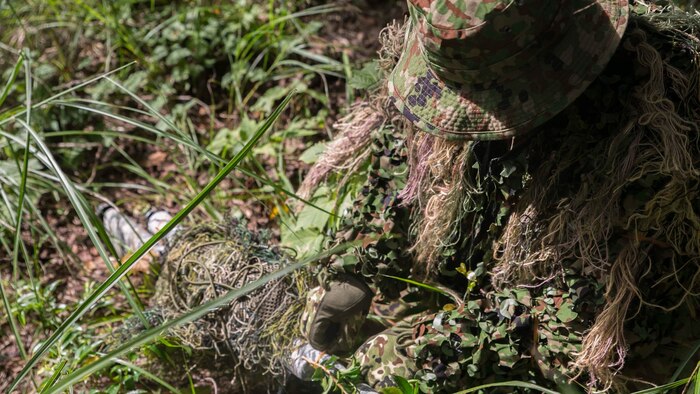 Japan Ground Self-Defense Force Sgt. Akito Yagi attaches vegetation to his sniper rifle while performing stalking drills during Forest Light 16-1 at Camp Imazu, Takashima, Japan, Sept. 10, 2015. The Marines sat up on a high embankment, trying to catch the JGSDF stalking the target with binoculars. Forest Light is a semiannual, bilateral exercise consisting of a command post exercise and multiple field training events, conducted by elements of III Marine Expeditionary Force and the JGSDF. Yagi is a sniper with 50th Infantry Regiment, 14th Brigade. 