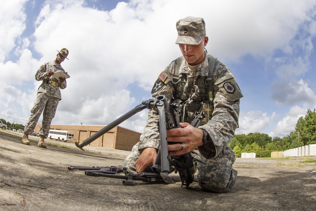 Army Staff Sgt. Russell Vidler, foreground, disassembles the M249 Squad Assault Weapon during the Army Training and Doctrine Command Drill Sergeant of the Year competition on Fort Jackson, S.C., Sept. 8, 2015. Vidler is a Reserve drill sergeant assigned to the 98th Training Division. U.S. Army photo by Sgt. 1st Class Brian Hamilton