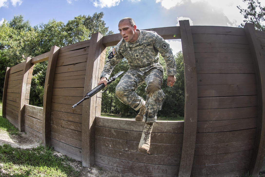 Army Staff Sgt. Russell Vidler leaps through a window at the Fit to Win obstacle course during the Army Training and Doctrine Command Drill Sergeant of the Year competition on Fort Jackson, S.C., Sept. 9, 2015. Vidler is a Reserve drill sergeant assigned to the 98th Training Division. U.S. Army photo by Sgt. 1st Class Brian Hamilton 