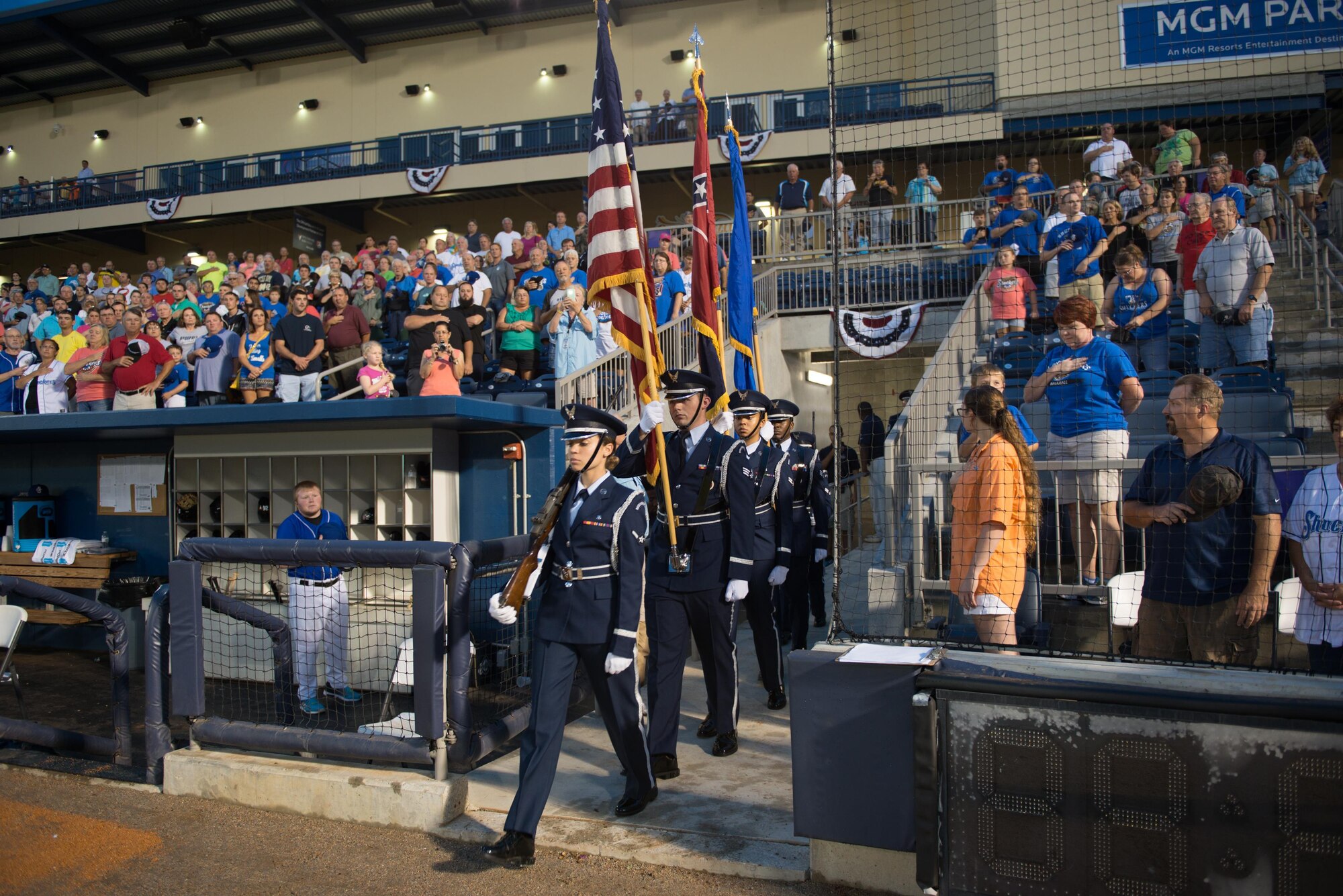 Members of the Keesler Air Force Base Honor Guard march onto the field to post the colors during a remembrance ceremony at the Biloxi Shuckers Minor League Baseball game Sept. 11, 2015, at MGM Park, Biloxi, Miss. The event honored those who lost their lives during the 9/11 attacks. It also included first pitches by a member of the local police department, fire department, each military service branch and a 21-gun salute and the playing of taps by the Keesler Honor Guard. (U.S. Air Force photo by Marie Floyd)