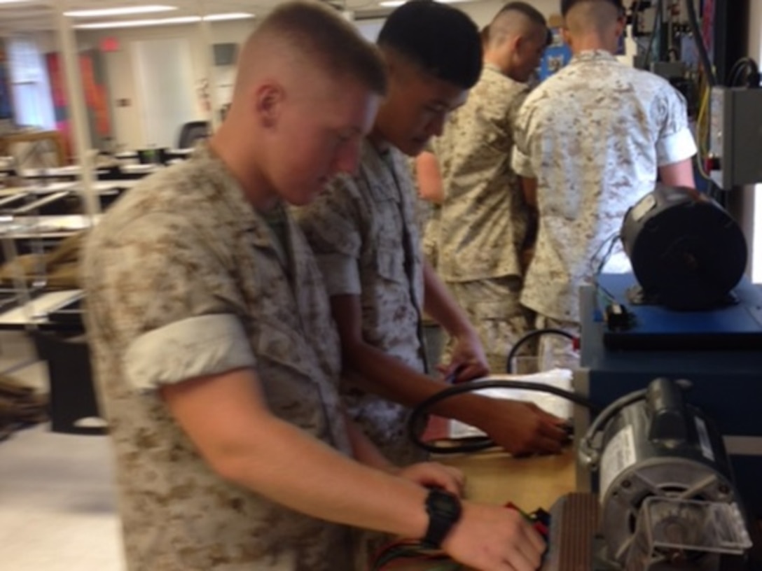 (From Left to Right) PFC Cheung and PFC Jordan from Basic Engineer Electrical Equipment Specialist Technician course 8-15  participate in a practical application exercise consisting of wiring up different types of motors taught by Sgt Pelt at Marine Corps Engineer School, Camp Lejeune, N.C. August 31, 2015.  This task is 1 of 17 the students must master in order to receive the 1142 Military Occupational Specialty (MOS).

