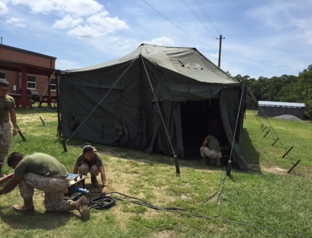 Marines attending Basic Electrician course 8-15 are seen conducting Electrical distribution system practical application at Marine Corps Engineer School, Camp Lejeune, N.C. August 31, 2015.  This portion of training focuses on power distribution from a generator site to a distribution panel and ending inside of a General Purpose (GP) tent.  The class also receives instruction on erecting GP tents.
