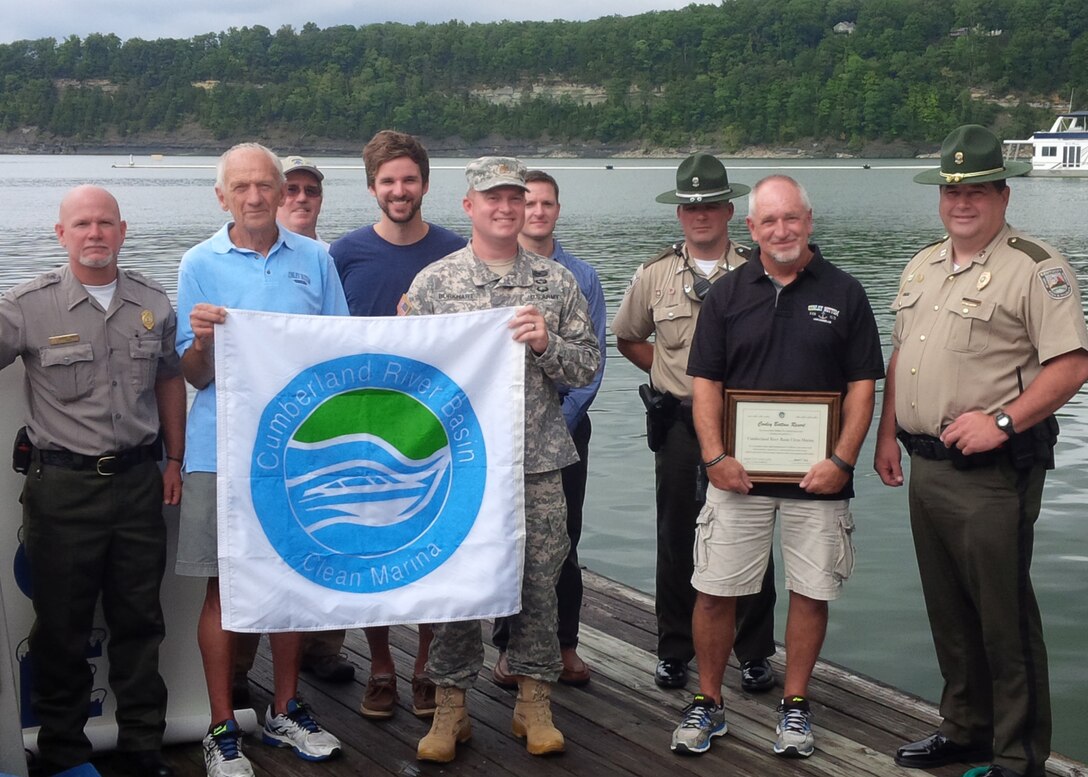 U.S. Army Corps of Engineers Nashville District Deputy Commander Maj. Christopher Burkhart presents a “Clean Marina” Flag to Conley Bottom Resort Owner, Charlie Denny at Lake Cumberland in Monticello, Ky., Sept., 10, 2015.  They celebrated the marina’s certification in the Cumberland River Basin Clean Marina Partnership, a commitment to pollution prevention and water resource protection.  In the photo are (Left to Right) Marshal Jennings, Environmental Protection Specialist, Charlie Denny, Conley Bottom Resort owner, Nashville District Deputy Commander Maj. Christopher Burkhart, Resort Manager Fred Piercy, and Stuart Bryant, Kentucky Department of Fish and Wildlife Resources Officer. 
Second row: (Left to right) Mark Vaughan, Environmental Protection specialist, Nashville District Jed Grubbs, Program Manager of Watershed Planning and Restoration, Cumberland River Compact, Mark Klimaszewski, Lake Cumberland Resource manager and Travis Neal, Kentucky Department of Fish and Wildlife Resources Officer 
